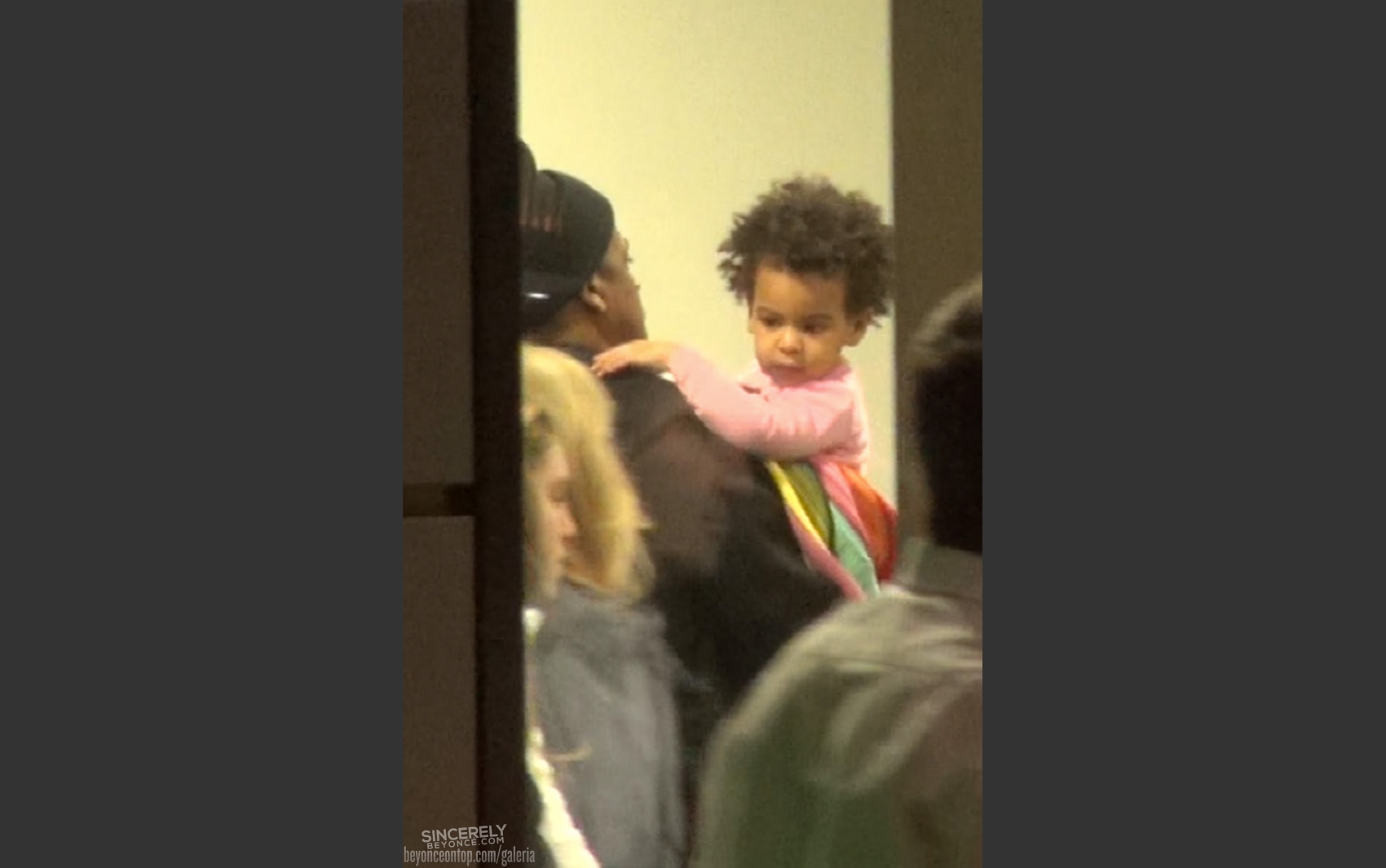 Jay-Z carrega Blue Ivy no colo. 